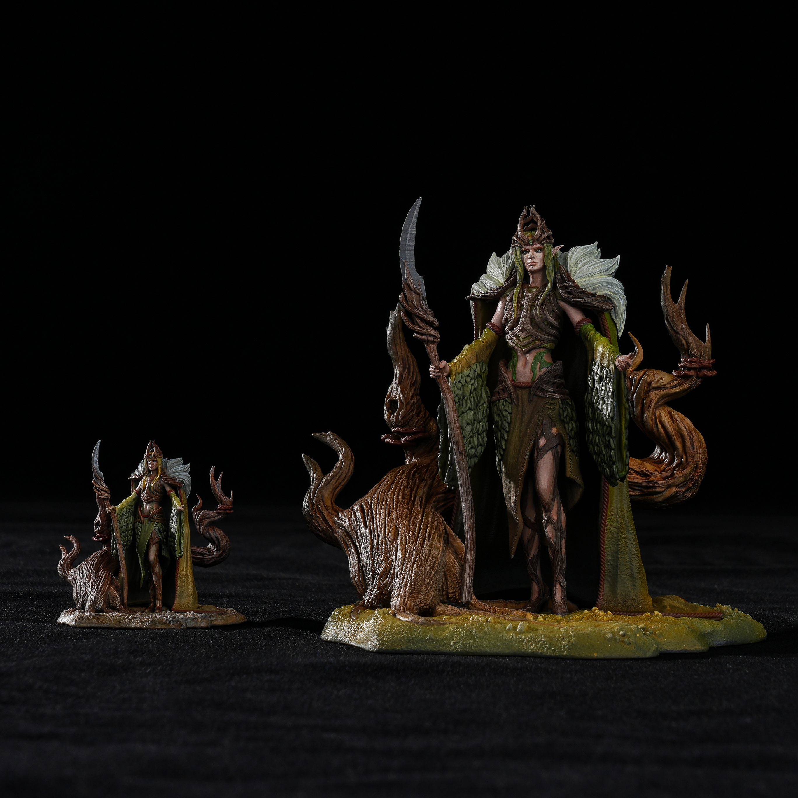 Comparison of 75mm master-painted Sylvan Queen Galadren figure beside a standard 32mm miniature for scale.